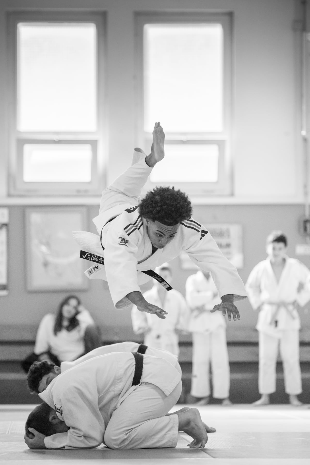 Judoka ceinture noire en plein saut au-dessus de son partenaire lors des portes ouvertes du Judo Club Catalan à Perpignan — photographie noir et blanc