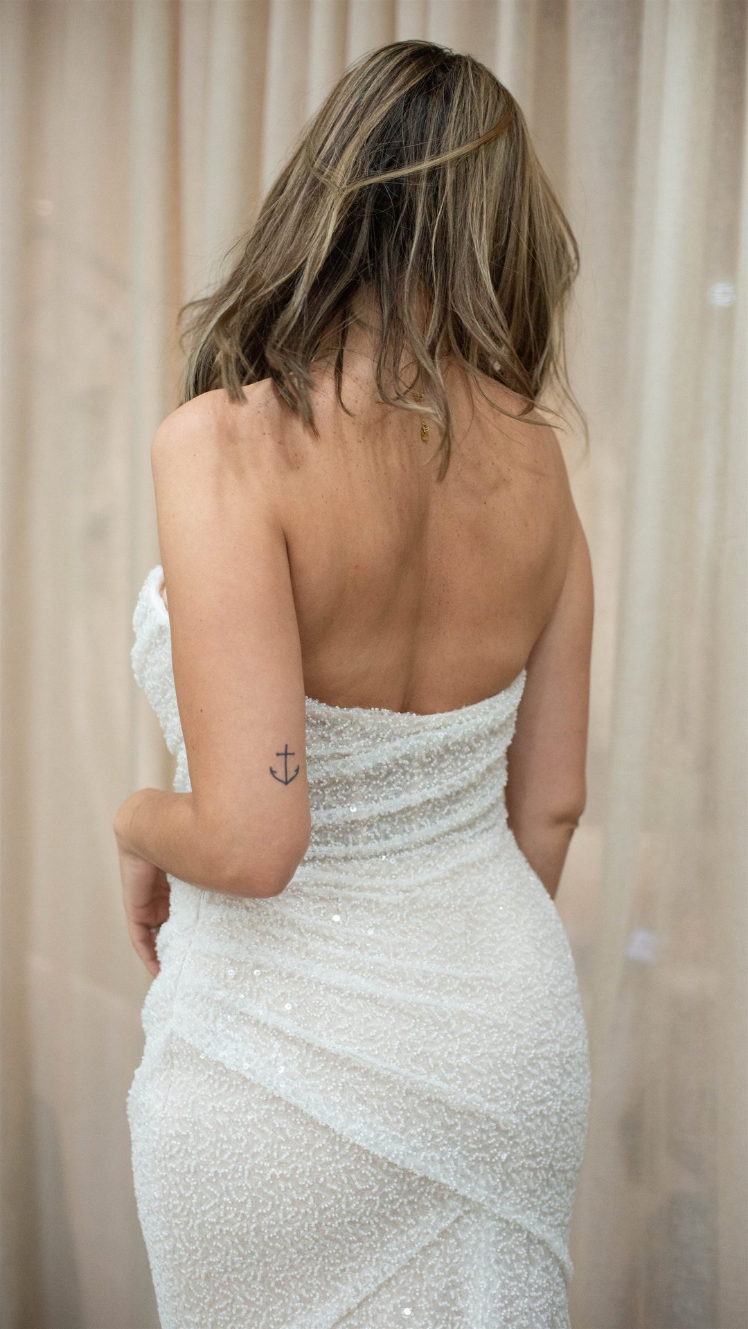Dos nu de la mariée en robe sequins avec tatouage ancre, version couleur — Perpignan
