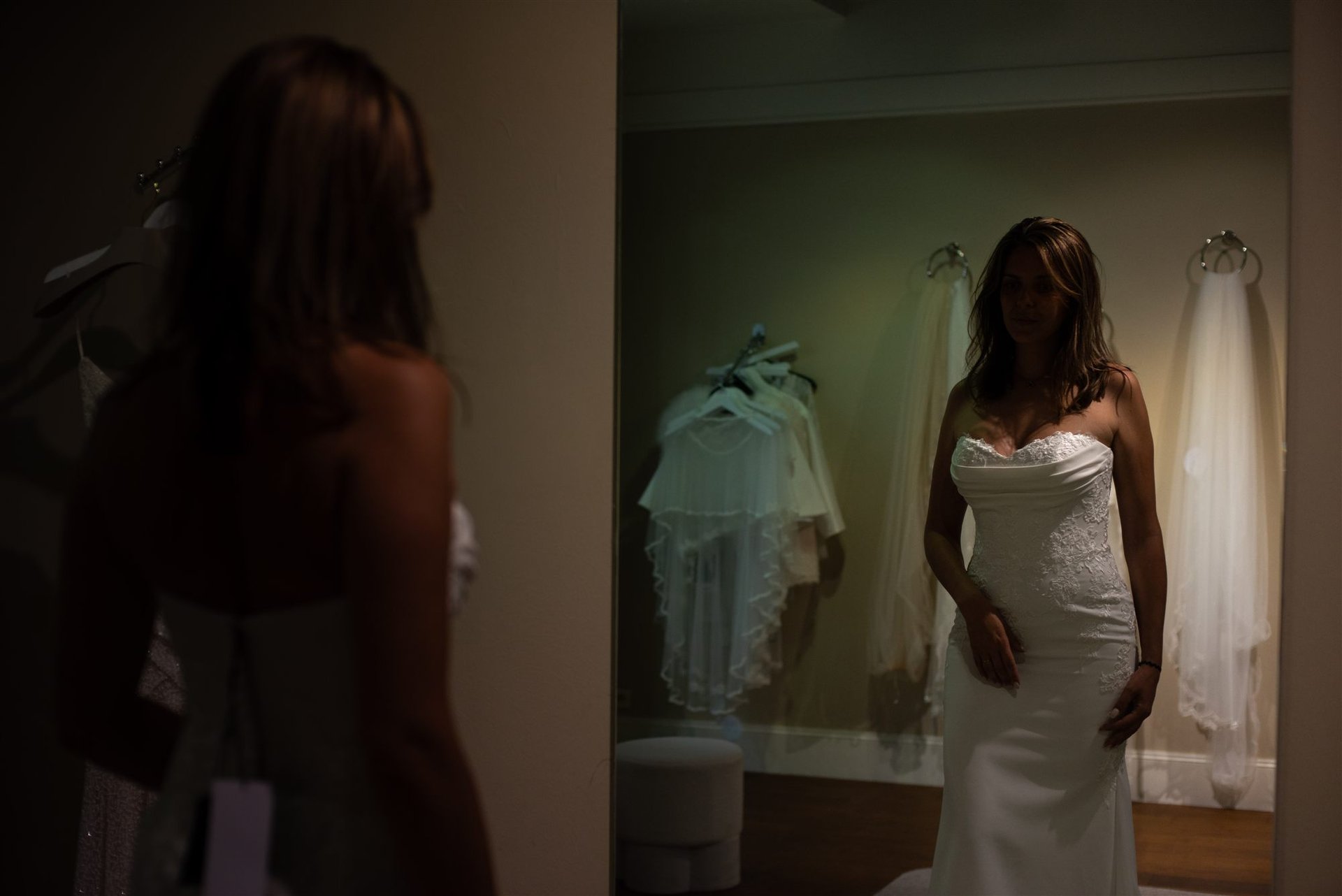 Mariée en robe de mariée face au miroir dans la loge de Côté Mariage Perpignan, lumière chaude