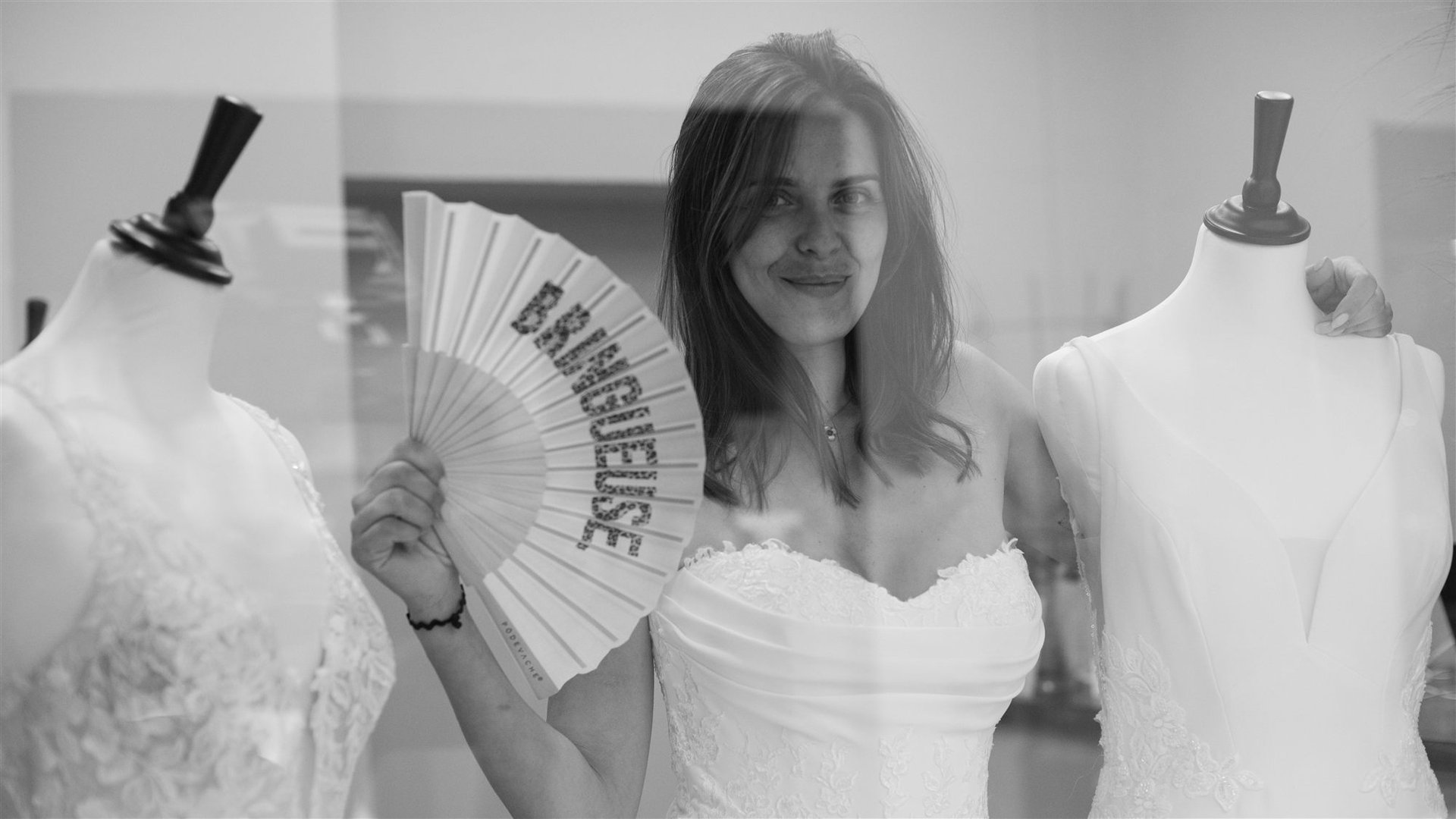 La mariée avec un éventail entre les mannequins de robes chez Côté Mariage Perpignan