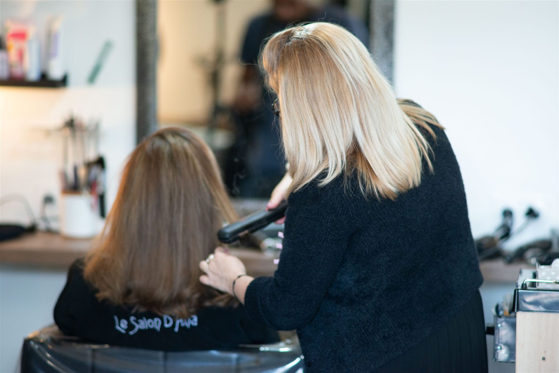 Annabel de dos avec un lisseur travaille les cheveux d'Amandine — vue d'ensemble du Salon D'Ana Perpignan