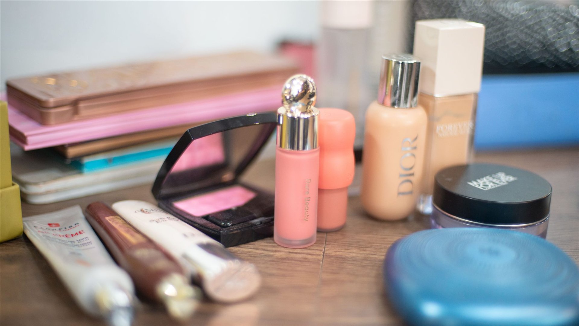 Produits de maquillage disposés sur une table — fond de teint Dior, blush, pinceaux — Magali Esthétique Perpignan