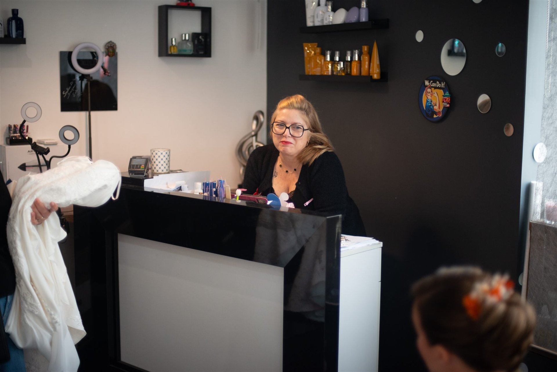 Vue d'ensemble finale du Salon D'Ana à Perpignan — Annabel derrière le comptoir, Amandine coiffée et fleurie en avant-plan